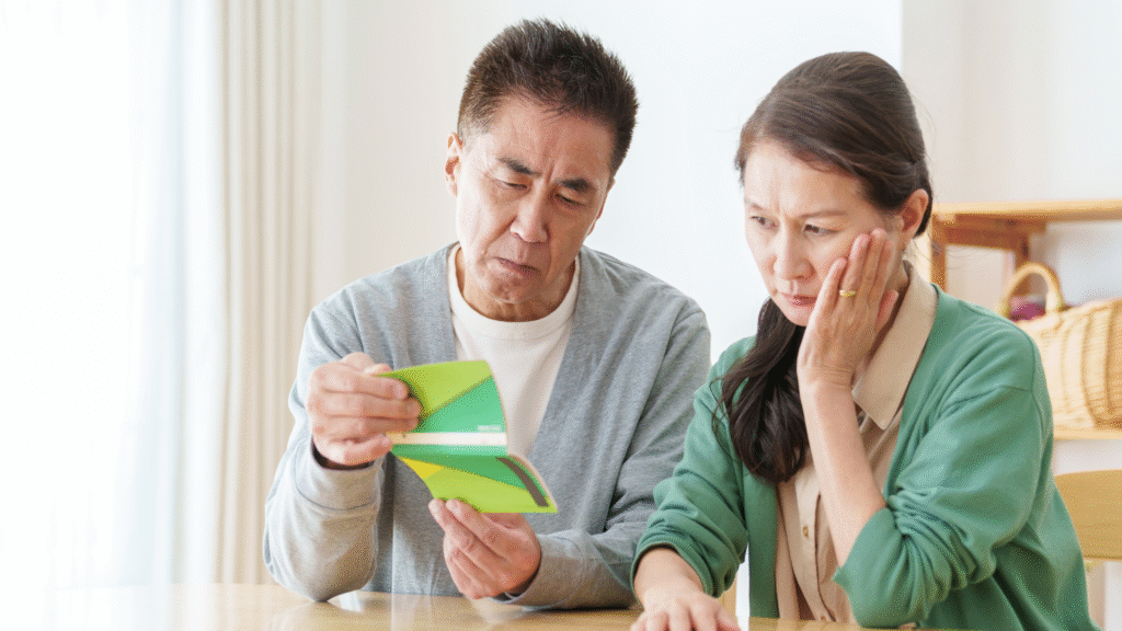 銀行通帳を見て困っている老夫婦