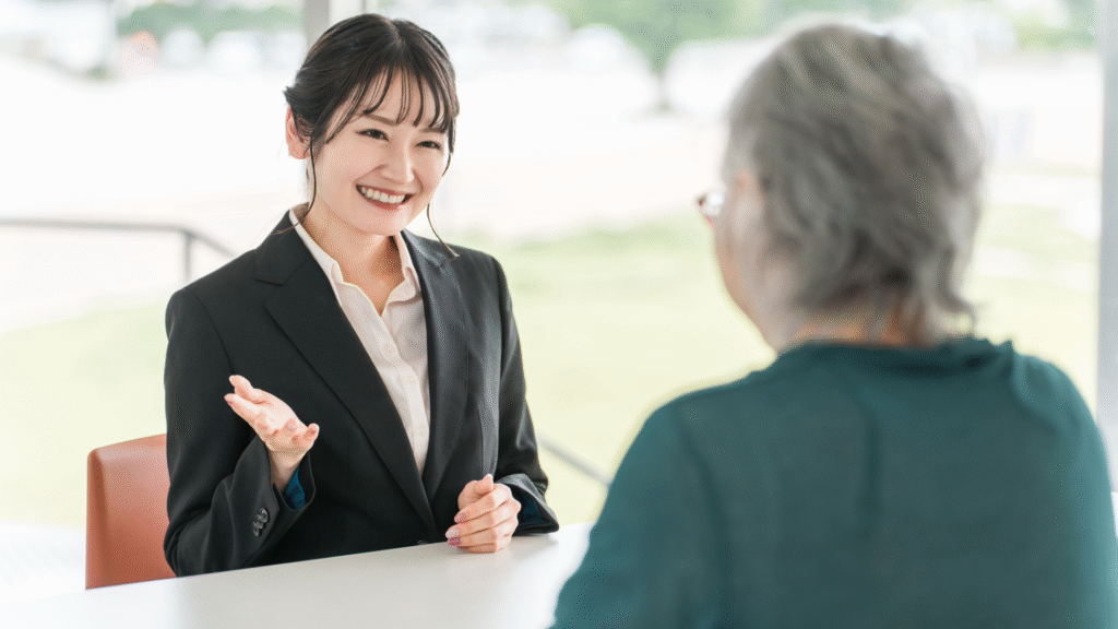 スーツ姿の女性に説明を受けている高齢女性