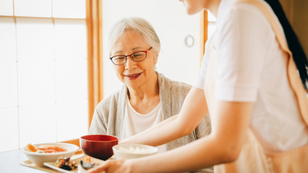 ヘルパーから食事を準備してもらっている高齢女性