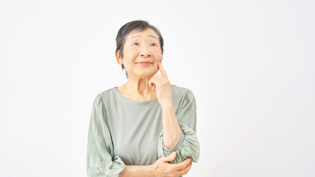 あごに手を置いて悩んでいる高齢女性