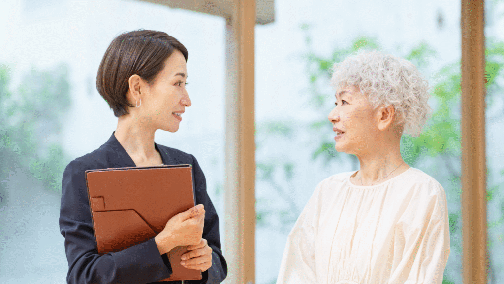 スーツ姿の中年女性と話している高齢女性