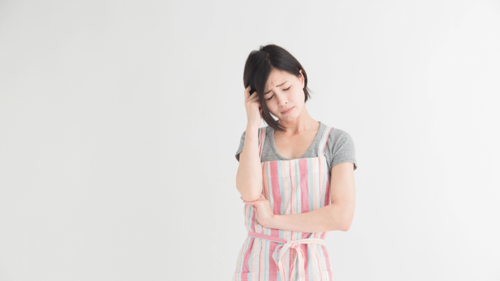 頭を抱えて悩んでいる中年女性